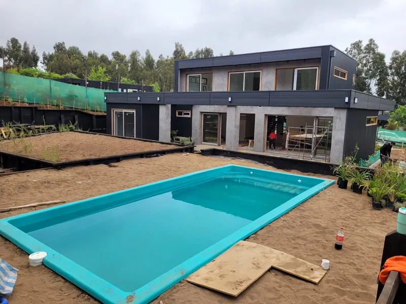 Vivienda durante la obra, con terreno sin terminar y piscina recién instalada