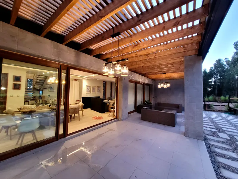 Terraza con piso de porcelanato de gran formato y muros revestidos en piedra
